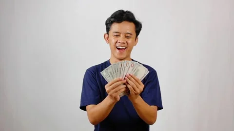 Man counting cash with a happy expression, Stock Footage 318453641