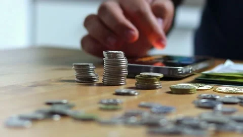 Man counting coins on table with calculator, financial concept Stock Footage 233822080