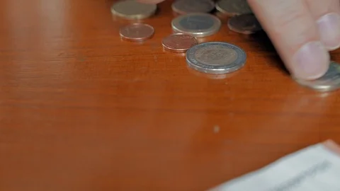 A man counting coins on a table. Stock Footage 101433599
