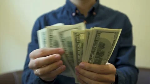 A man is counting dollar banknotes. Man holds cash in hands. economy and finance Stock-Footage 336260100