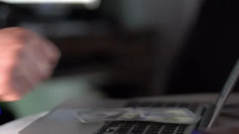 Man counting dollar bills and throwing on laptop keyboard Stock Footage 73457649
