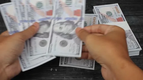 Man counting dollar bills on black table Stock Footage 309898067