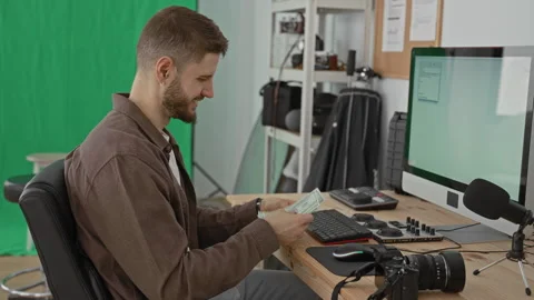 Man counting dollars with hands beside camera and computer in studio worksp.. Stock Footage 337365566