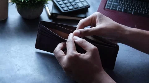 Man counting expenses and showing an empty money wallet on table with calculator Stock Footage 336450508