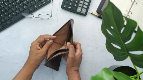Man counting expenses and showing an empty money wallet on table with calculator Stock Footage 336450625