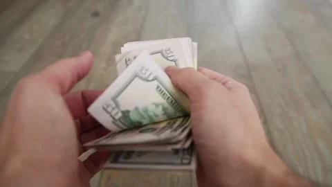 Man counting a large stack of USA currency by both hands. Man holds cash in.. Stock Footage 266476370