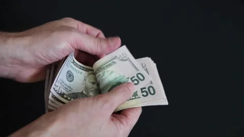 Man counting a large stack of USA currency by both hands. Man holds cash in Stock-Footage 336264767