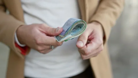 A man counting malaysian ringgit on an urban street, depicting finance, tra.. Stock Footage 270323780