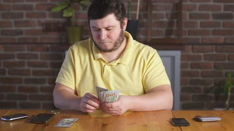 Man counting one hundred dollars bills and plans a budget. Home finance. Stock Footage 142991501