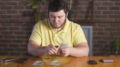 Man counting one hundred dollars bills and plans a budget. Home finance. 動画素材 142991732