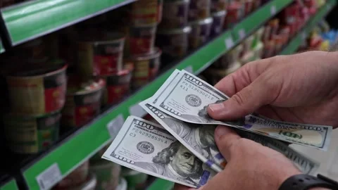 Man counting US 100 dollar banknotes in grocery store aisle Stock Footage 333167652