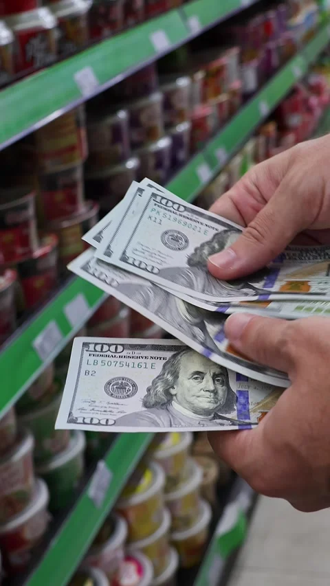 Man counting US 100 dollar banknotes in grocery store aisle Stock Footage 333167660