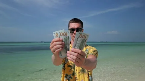 Man counting US dollars on tropical beach Stock Footage 258809661