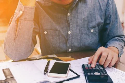 Man counting using calculator and stress in problem with expenses. Stock Photos