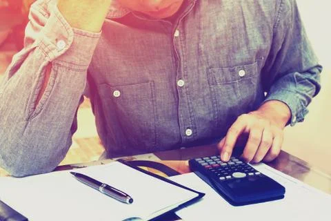 Man counting using calculator and stress in problem with expenses at home o.. Stock Photos