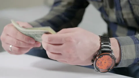 Man counting a wad of banknotes in a close up on his hands Stock Footage 166216917