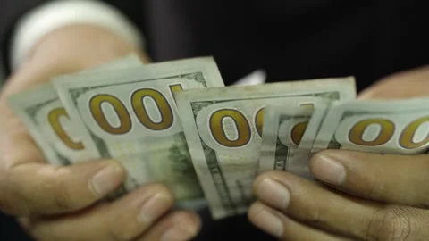 A man counting a wad of U.S. dollars Stock Footage 275350492