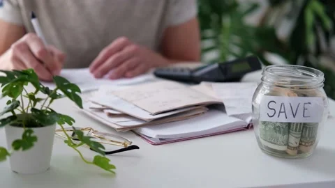 A man counts a bill on a calculator on the table. Stock Footage 187470588