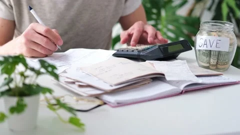 A man counts a bill on a calculator on the table. Stock Footage 237780495