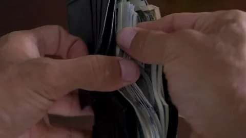 A man counts dollar banknotes in his wallet. man holding wallet and counting Видео 336261378