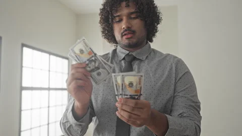 Man counts dollars and thumbs through a stack of cash, holding bills near c.. Stock Footage 337400671