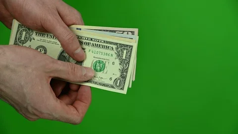 Man counts dollars on green background Stock Footage 129092988