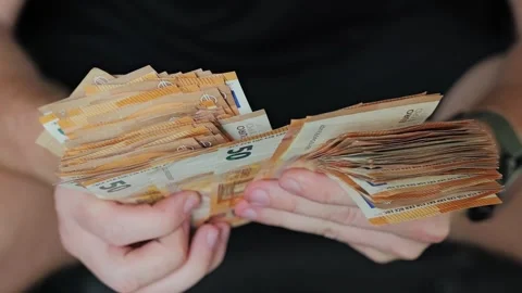 Man Counts Large Stack of Euro Banknotes While Sitting – Slow Motion View Stock Footage 312333460