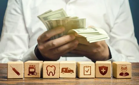 A man counts money over blocks with medical attributes symbols. High medica.. Stock Photos