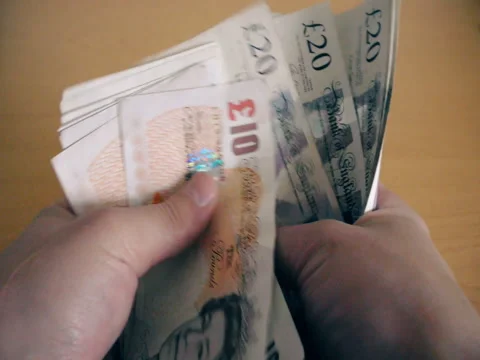The man counts money at the table. (British Pound) Stock Footage 72251926