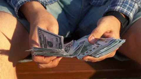 A man counts money while sitting on a bench Stock Footage 157580860