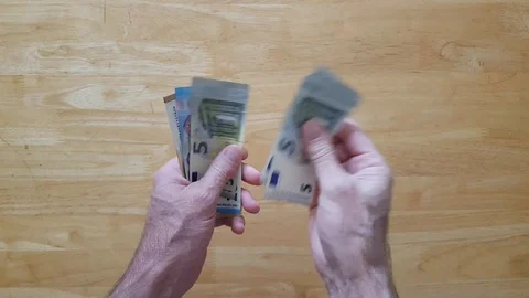 Man counts out Euro notes into one hand over a table Stock Footage 111011278