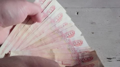Man counts red paper russian cash money. 5000 rubles bills in male hand Stock Footage 295695129