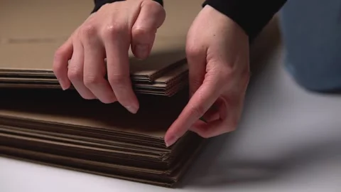 The man counts the sheets of cardboard lying on the floor Stock Footage 142778305