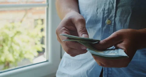 A man counts a stack of dollars at home. Stock Footage 226986770