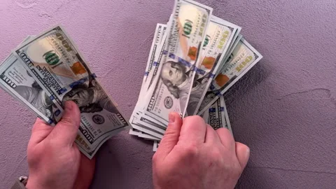 A man counts a wad of dollars over a table, top view, close-up on his hands Stock Footage 304755373