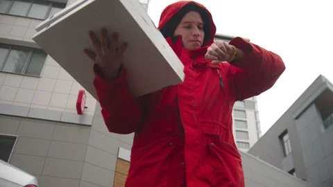 A man courier delivering pizza - looking around and waiting for the customer Stock Footage 129528517