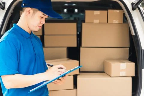 Man courier in uniform hold documents clipboard checking list parcel post box Stock Photos