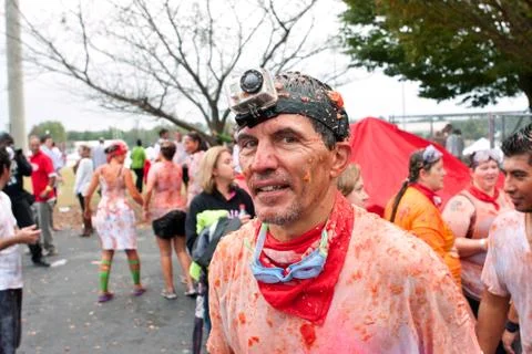 Man is covered in pieces of tomato after food fight Foto stock