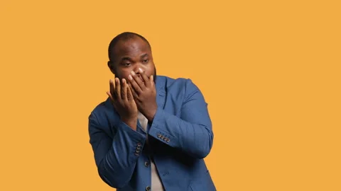 Man covering face with hands to avoid being recognized, studio background Stock Footage 272532419