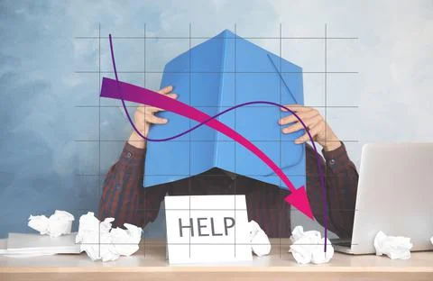 Man covering head with folder at table in office and illustration of falling  库存照片