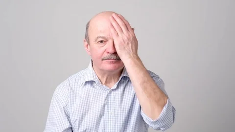 Man covering one eye during vision examination trying to see letters. Stock Footage 102803600