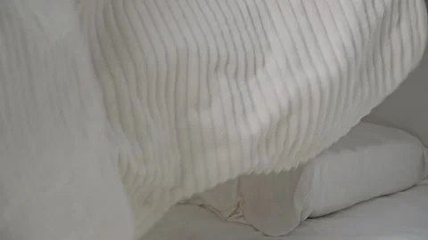 The man covers the bed with white blanket. Stock Footage 185509662