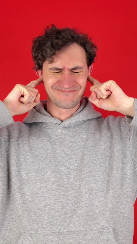 Man covers ears fingers, does not want listen screams, loud music Stock Footage 304761636