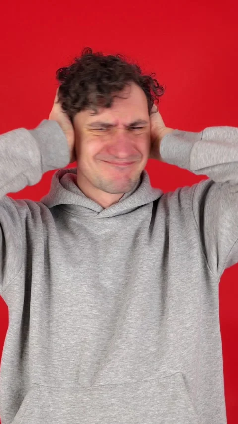 Man covers ears with palms, does not want to listen to screams, loud music 動画素材 304761633
