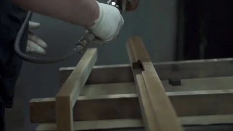 A man covers a tree with paint, paints a part with a spray. A factory worker  Stock Footage 84043361