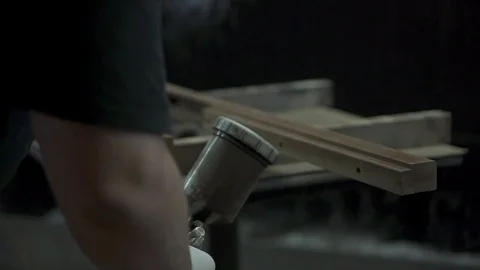 A man covers a tree with paint, paints a part with a spray. A factory worker  Stock Footage 84043374