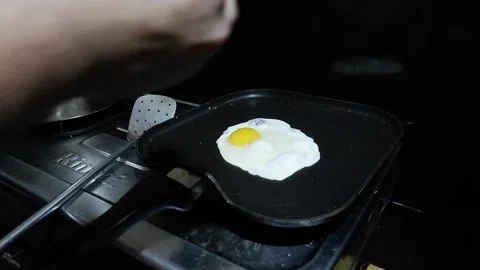 Man crack an egg on flat frying pan and season it Stock Footage 278510001
