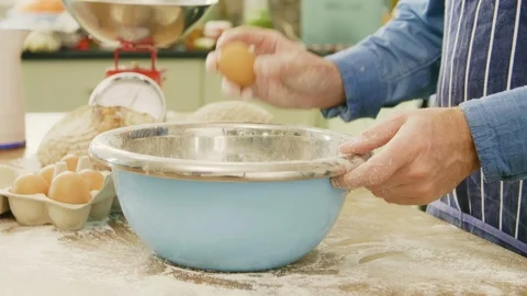 Man Cracking Eggs In Container At Table In Kitchen Stock Footage 86075192