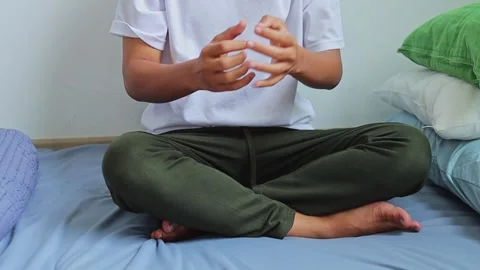 Man cracking knuckles and doing finger stretches in cozy bedroom Stock Footage 341994673