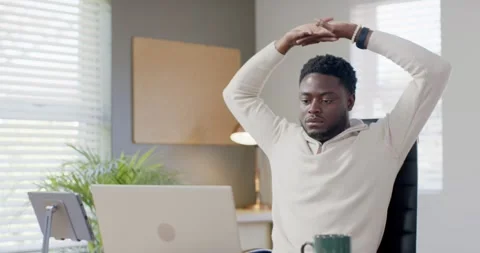 Man in cream pullover working at home office desk, focusing on laptop, Stock Footage 343888318